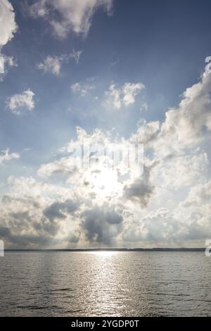 Sun shining dramatically through the clouds over the ocean Stock Photo