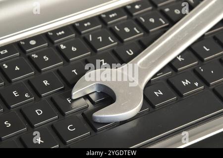 Wrench lying on computer keyboard symbolizing IT maintenance Stock Photo