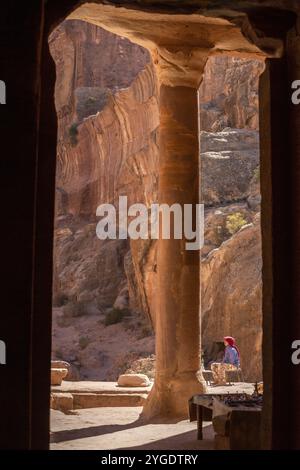 Petra, Jordan, November 3, 2022: Bedouin man and view from Garden Temple to the colorful rocks at Wadi Farasah trail, Asia Stock Photo