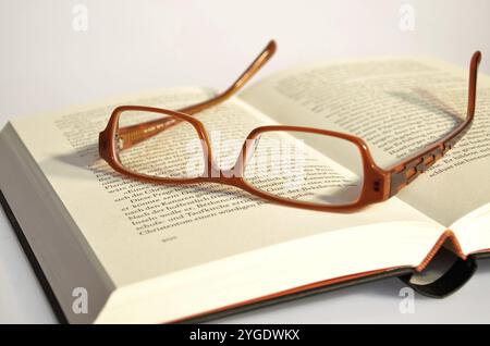 Reading glasses lying on a book Stock Photo