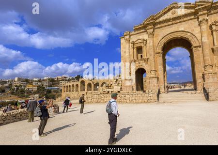 Jerash, Jordan, November 7, 2022: Tourists in front of Arch of Hadrian at the entrance of the archeological site, Asia Stock Photo