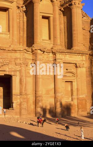 Petra, Jordan, November 3, 2022: People, donkey at Ad Deir Monastery in the ancient city, sunset panoramic view, UNESCO World Heritage Site, Asia Stock Photo