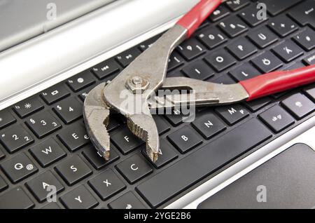 Wrench lying on computer keyboard Stock Photo