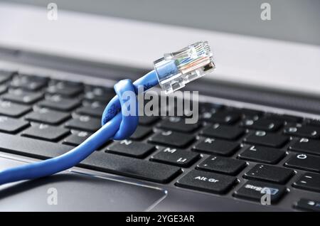 Internet cable with knot on a computer keyboard Stock Photo