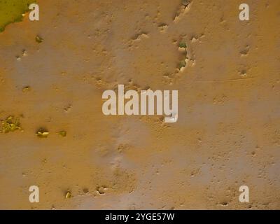 Wall with peeling yellow paint from a steel beam. The rust shows through. Stock Photo