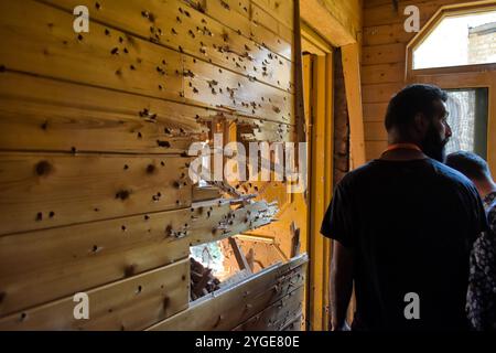 People asses the damaged residential house in Srinagar, Indian Administered Kashmir on 10 April 2022. Two foreign militants were killed in an encounter with Indian forces. Stock Photo