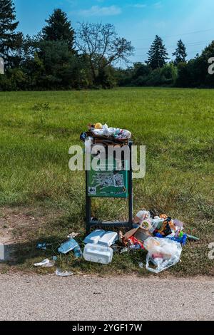 overflowing trash can in a park Stock Photo