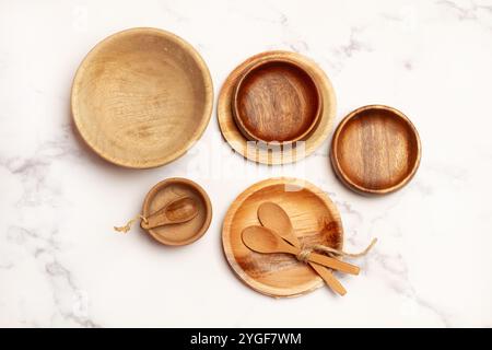 Wooden plates and spoons on a marble kitchen countertop in a top view Stock Photo