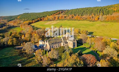 Pluscarden Abbey Catholic Benedictine monastery near Elgin Scotland surrounded by vibrantly coloured trees in autumn sunshine Stock Photo