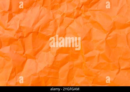 Top view and full frame of wrinkled or crumpled orange paper is used as crumpled orange paper background texture. Stock Photo