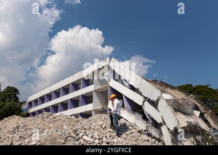Engineer holding tablet is checking for destruction, demolishing building. Stock Photo