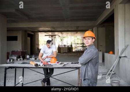 Architect, Engineer, Contractor, or Construction manager standing with arm cross at a construction site. Stock Photo