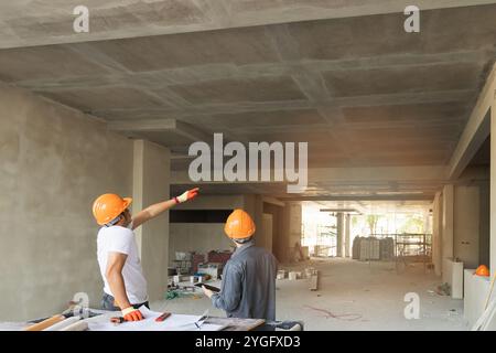 Confident team of architect working together in building construction site. They discussing about new startup project. Architect discuss with engineer Stock Photo