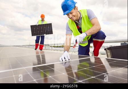 Positive Technician Installing And Servicing Solar Panels Stock Photo