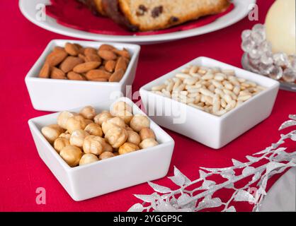 Pine nuts, almonds and hazelnuts in bowls on the Christmas table. Stock Photo