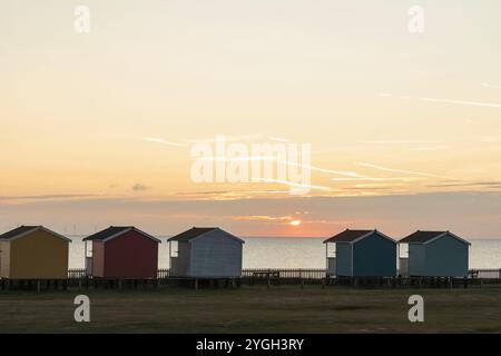 England, Kent, Isle of Sheppey, Leysdown on Sea, Sunrise over Colourful Beach Huts Stock Photo