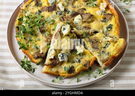 omelette with blue cheese, rye croutons and fresh thyme on plate on tablecloth Stock Photo