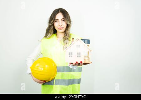 Home inspector woman or engineer holding detached house model Stock Photo