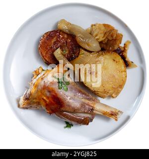 Baked lamb with roasted potatoes and onion served with sauce Stock Photo