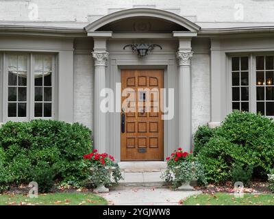House with elegant wood grain front door and columns Stock Photo