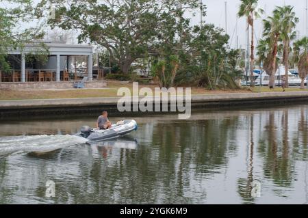 Editorial Use Only,  November 7, 2024. Gulfport, FL, USA. Leading lines sea wall view across outlet to Boca Ciega Bay to Small motor boat heading in o Stock Photo
