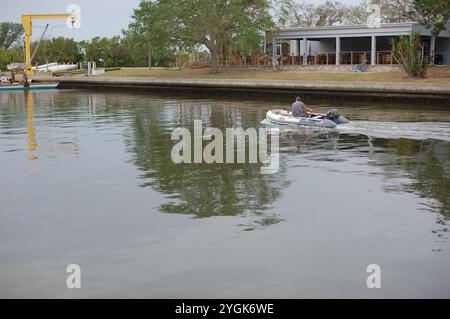 Editorial Use Only,  November 7, 2024. Gulfport, FL, USA. Leading lines sea wall view across outlet to Boca Ciega Bay to Small motor boat heading out Stock Photo