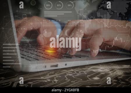 Technology and business. Man working on laptop at table and graphs with schemes, double exposure Stock Photo