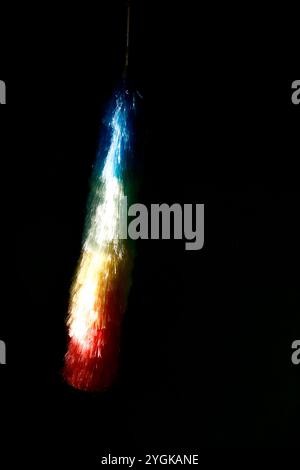 rainbow-colored feather duster on black background Stock Photo
