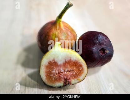 Fig fruits with slices of fig on wooden table Stock Photo