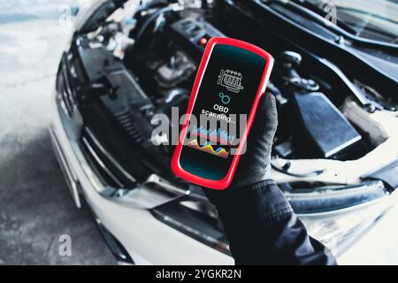 OBD scanner tools , OBD Scanner in use by mechanic over car engine background for analysis engine system problems , Car repair concept Stock Photo