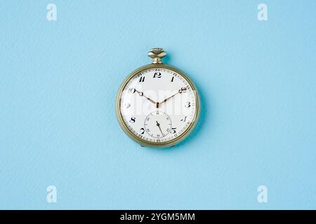 Top view of antique pocket watch on blue background Stock Photo