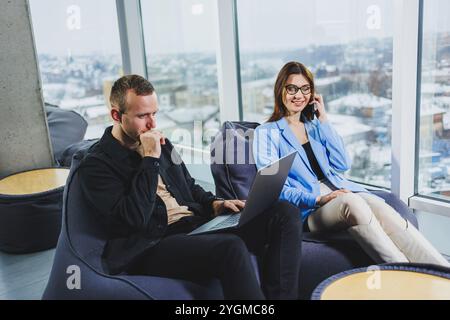 Two business people working remotely online using a laptop. Colleagues work remotely in the workspace. Stock Photo