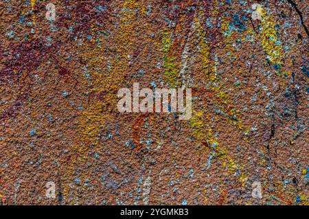 White plastered wall splattered with red paint. Paint splashes on the wall. Painted plaster wall. Abstract background. Painted plaster texture. Stock Photo
