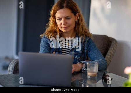 Young beautiful woman using laptop on garden terrace Stock Photo