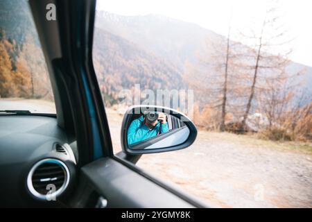 Photographer captures reflection in car mirror during mountain drive Stock Photo