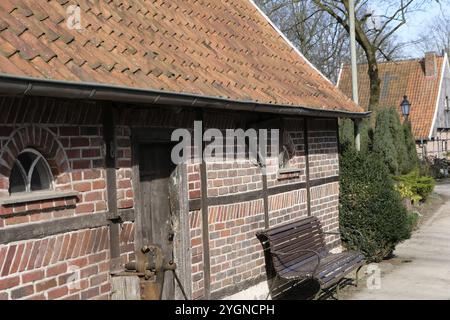 Half-timbered house with tiled roof in rural surroundings, rustic with wooden bench in front, weseke, muensterland, germany Stock Photo