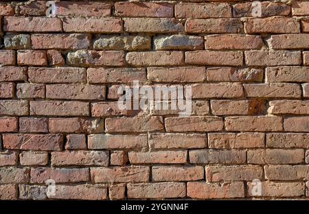 Background with old wall made with handmade brick made out of clay. Stock Photo
