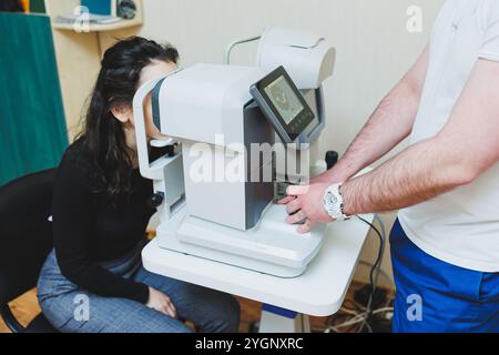 Eye examination of a young woman at an ophthalmologist's appointment using modern microscopes. Vision treatment using modern equipment Stock Photo