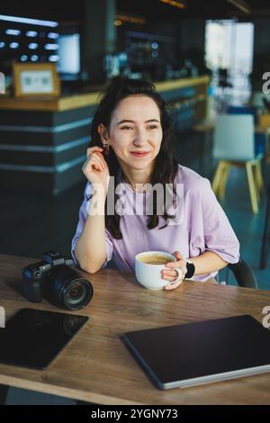 A female photographer works on a computer at her desk. A young woman uses a tablet to retouch an image. Stock Photo