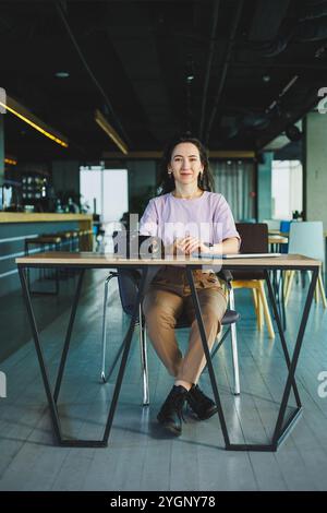 A female photographer works on a computer at her desk. A young woman uses a tablet to retouch an image. Stock Photo