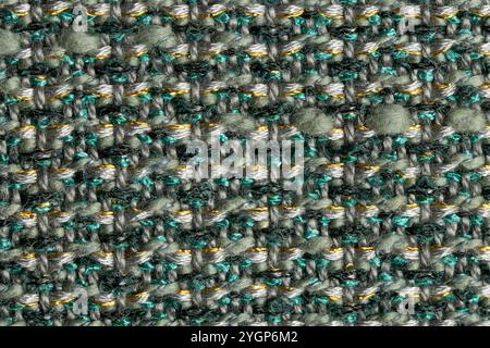 close up macro shot of textured woven cloth in shades of  green, gray and teal with a small amount of gold thread, for a background, with shallow dept Stock Photo