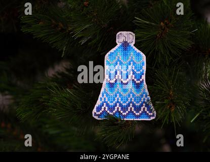 Blue bell cross stitched Christmas ornament on Christmas tree. Stock Photo