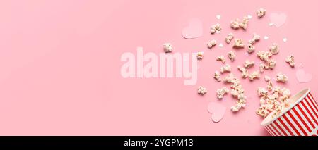 Scattered popcorn and hearts on pink background with space for text. Valentine's Day celebration Stock Photo