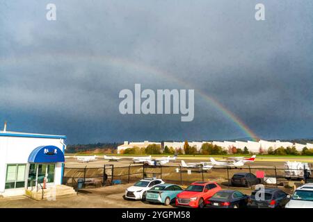 A brisght rainbow arches over an airpot in Renton, Washington. Stock Photo