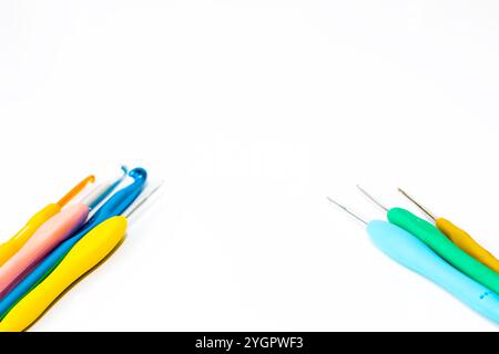 Various size bright crochet hooks isolated on white background. Copy space, top view, flat lay. knitting idea concept. Colorful crochet hooks. Stock Photo