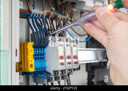 Hand Using Voltage Tester on Electrical Connections Stock Photo