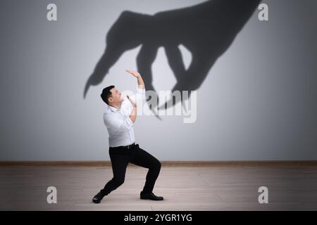 Man scared by monstrous hand reaching for him. Creepy shadow on light ...