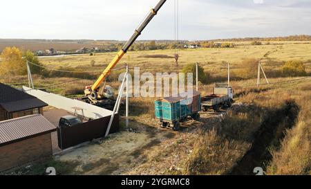 Unloading using a crane. The crane is working, loading into the truck. Mobile crane, large lifting weight, lifting capacity of heavy-duty port cranes. Stock Photo