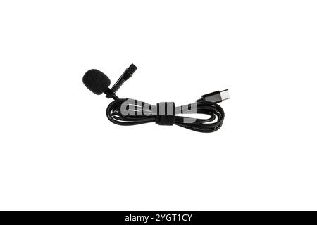 A black lavalier microphone with a foam windscreen and a USB-C connector, neatly coiled with a Velcro strap, isolated on a white background. Stock Photo