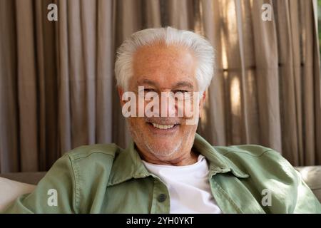 Smiling senior man relaxing at home, enjoying peaceful holiday moment Stock Photo